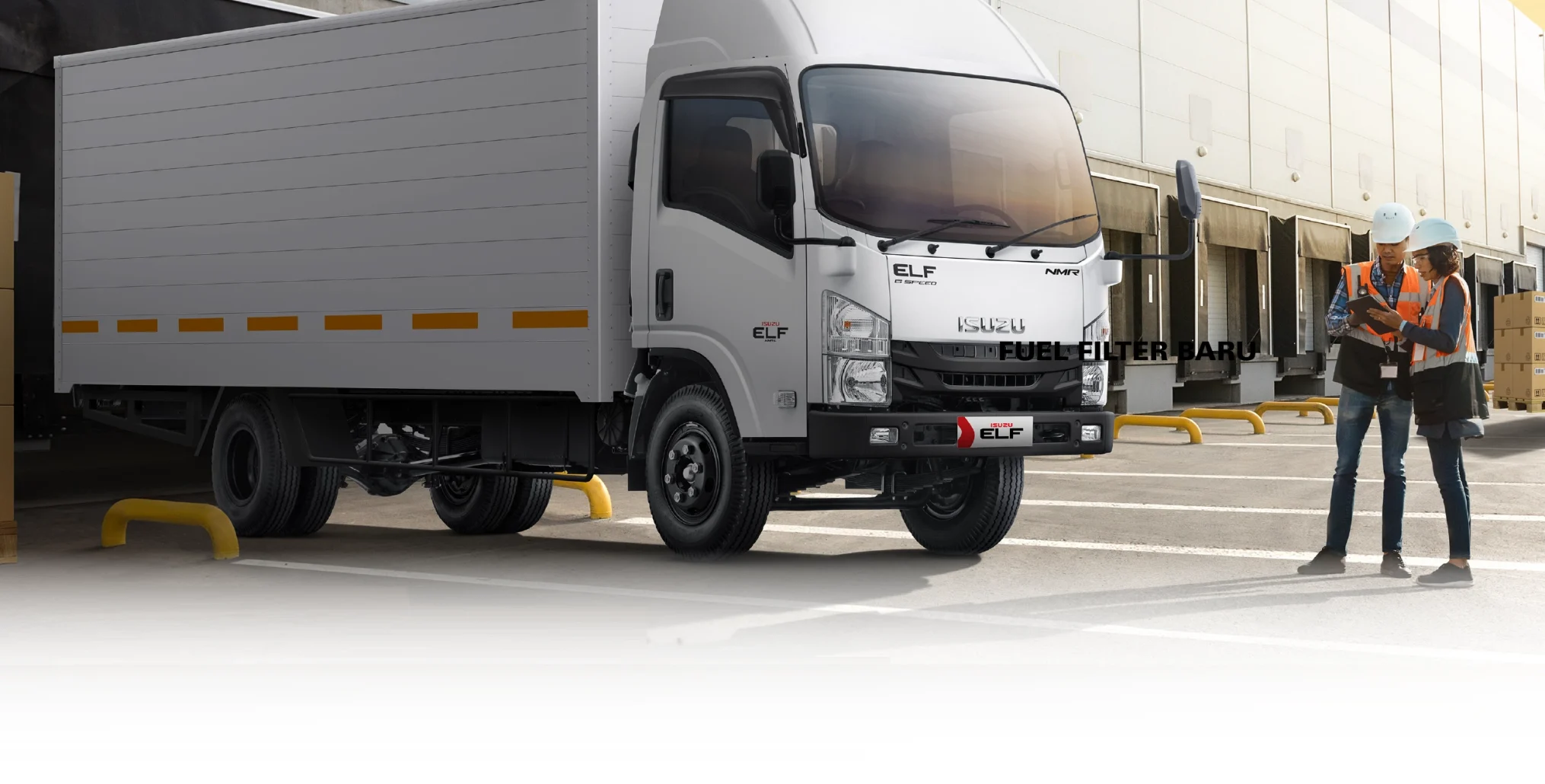 gambar unit isuzu ELF NMR yang sedang parkir digudang logistik